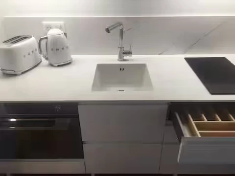 alt="Studio – Cuisine équipée avec mini-réfrigérateur et plaques de cuisson"