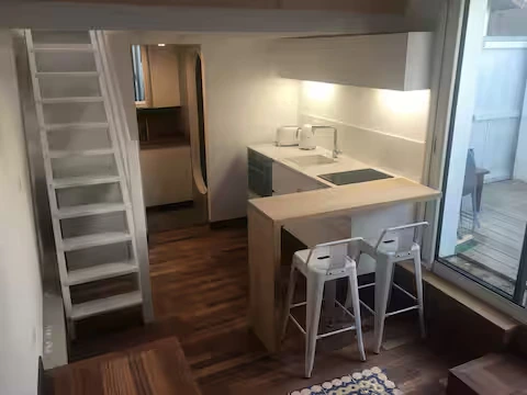 Alt="Studio – Vue intérieure lumineuse avec décoration moderne"