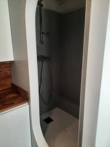 alt="Studio – Salle de bain moderne avec douche et lavabo"