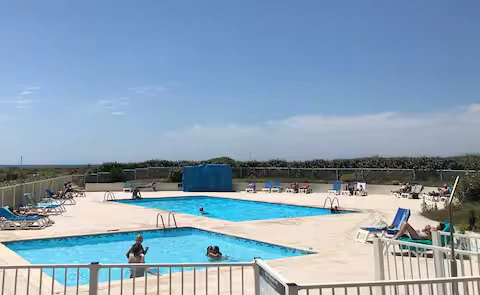 alt="T2 – Piscine commune de la résidence avec espace détente extérieur"