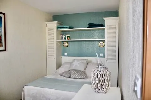 alt="Résidence – Chambre avec lit double de 140 cm et rangements spacieux"