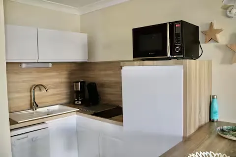 alt="Résidence – Cuisine équipée avec micro-ondes, plaques vitrocéramiques et lave-vaisselle"