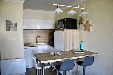 alt="Résidence – Cuisine équipée avec micro-ondes, plaques vitrocéramiques et lave-vaisselle"