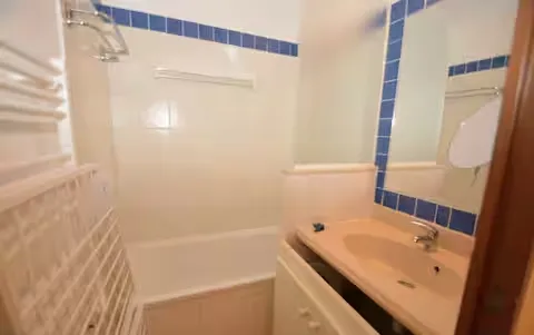 alt="Résidence – Salle de bain moderne avec baignoire/douche et sèche-serviettes"