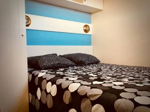 alt="T2 – Chambre avec trois lits simples et rangements spacieux"