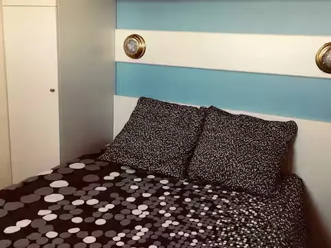 alt="T2 – Chambre avec trois lits simples et rangements spacieux"