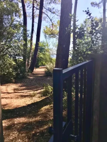 portail du jardin menant directement au lac et ses petites plages de sable presque privees devant la maison 26 768x1024